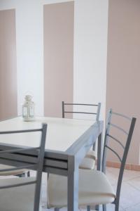 a dining room table and chairs with a white table at Appartamento Il Castello in Casale Monferrato