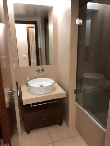 a bathroom with a sink and a mirror and a shower at Salgados Beach in Albufeira