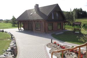 una piccola cabina in legno con un passaggio in pietra di fronte di Relax House a Varkaliai