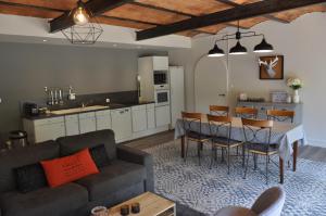 a living room and kitchen with a couch and a table at Au Rez de Jardin in Cholet