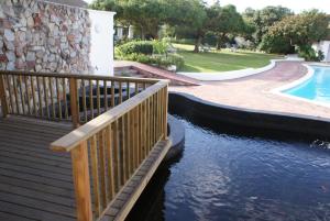 una pasarela de madera junto a una piscina en Whale Rock Luxury Lodge en Hermanus