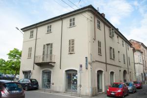 a large white building with cars parked in front of it at Appartamento Il Castello in Casale Monferrato