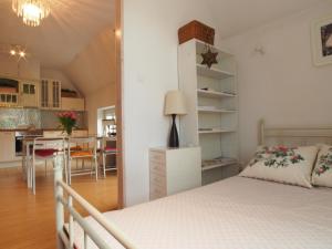 グダニスクにあるGrand Tourist Mansard, Długa 69 Strのベッドルーム1室(ベッド1台付)、キッチン(テーブル付)