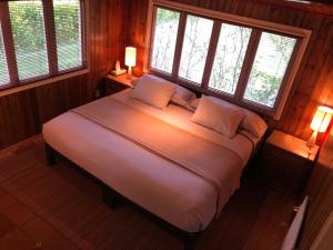 a bedroom with a large bed with two windows at Rancho Viejo in El Aguaje
