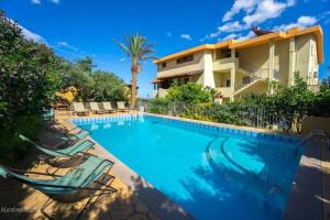 a swimming pool with two lawn chairs and a building at Hotel La Playa in Cala Gonone