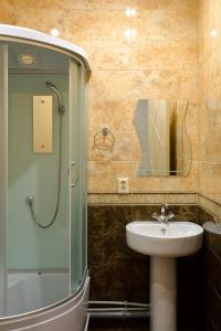 a bathroom with a sink and a shower with a mirror at Guest House on Partizanskaya in Barnaul