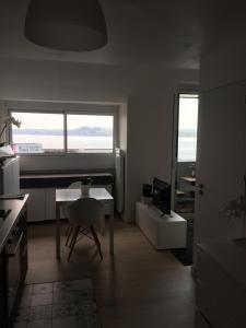 uma sala de estar com uma secretária, uma mesa e uma janela em Appartement Design IV - Port du Rosmeur - Douarnenez em Douarnenez