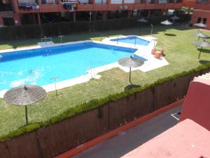 een uitzicht over een zwembad met parasols bij Apartamento a la Playa in Algeciras