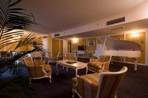 a hotel room with a piano and a living room at Grand Hotel Bucharest in Bucharest