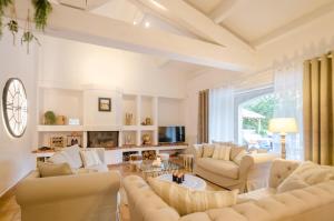 a living room with white furniture and a fireplace at Villa Siena in Roquebrune-sur-Argens