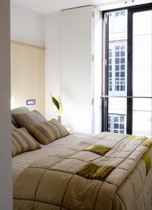 オウレンセにあるBalcon das Burgasの大きな窓付きの客室の大型ベッド1台分です。
