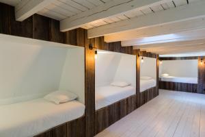 ニーウポールトにあるMaison Albertの木製の壁の客室で、二段ベッド2組が備わります。