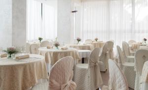 a dining room with white tables and white chairs at Hotel Tulipe Nazionale in Riccione