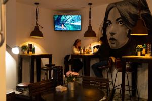 a bar with a large painting of a woman at Winederful Hostel & Café in Logroño
