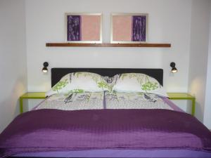 łóżko z fioletową kołdrą i dwoma oknami w obiekcie Apartments Karmen Pula w Puli