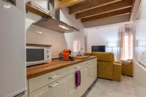 eine Küche mit einer Spüle und einer Mikrowelle in der Unterkunft Loft / Duplex with charming historic center. WIFI in Sevilla