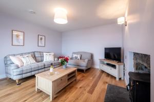 a living room with a couch and a tv at Lochside in Staffin