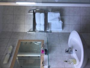 ein Badezimmer mit einem Waschbecken, einem Urinal und Handtüchern in der Unterkunft Meeresblick Ferienwohnung in Husum