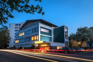 a building with cars parked in front of a street at Hotel Servatius in Cologne