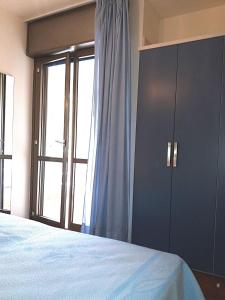 a bedroom with a bed and a large window at Acapulco in Bibione