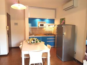 a kitchen with a table and a stainless steel refrigerator at Acapulco in Bibione