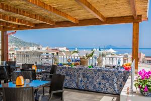 un patio con mesas y sillas y vistas al océano en Casa Papiro, en Lipari