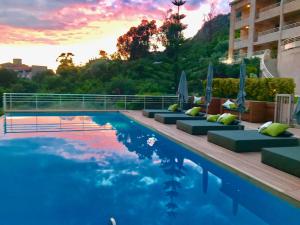 a swimming pool with lounge chairs next to a building at Hôtel et Résidence Costa Rossa in Porto Ota