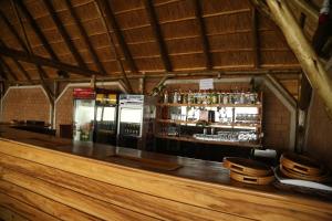 eine Bar mit einer Theke und einem Kühlschrank in der Unterkunft The Palms Beach Hotel in Entebbe