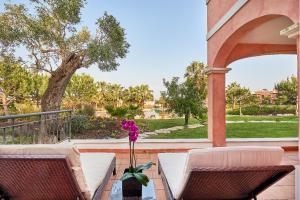 a patio with two chairs and a table with a flower in a vase at Cascade Wellness Resort in Lagos
