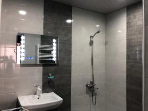 a bathroom with a shower and a sink and a mirror at Kutaisi Grand Suites in Kutaisi