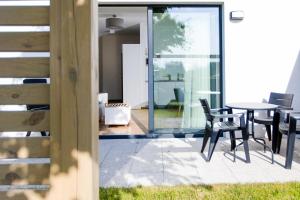 a dining room with a table and chairs on a patio at Apartamenty Villa Baltica Rewal in Rewal