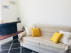sala de estar con sofá y almohadas amarillas en Vento di Mare, en Tellaro