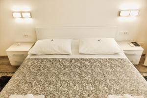 ein Schlafzimmer mit einem großen Bett mit zwei Nachttischen in der Unterkunft Old Square Apartment in Split
