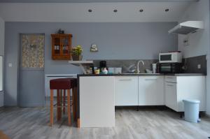 a kitchen with white cabinets and a counter top at Dans un jardin in Apremont-la-Forêt