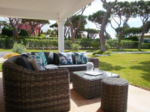 a wicker couch and a table on a patio at Fonte Santa by Check-in Portugal in Quarteira
