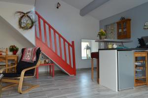 a living room with a staircase and a table and a chair at Dans un jardin in Apremont-la-Forêt