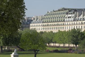 um grande edifício branco com árvores em frente em Le Meurice – Dorchester Collection em Paris