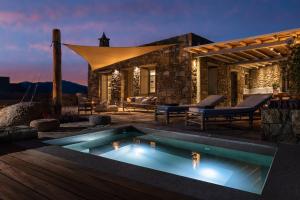 a villa with a swimming pool at night at Mykonos AG Villas in Ftelia Beach in Ftelia