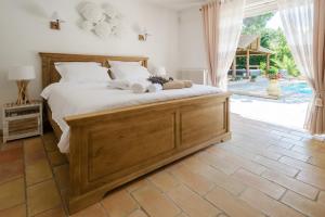 a bedroom with a large wooden bed and a patio at Villa Siena in Roquebrune-sur-Argens +69 photos