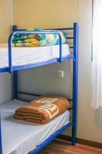 a bunk bed with towels on the bottom bunk at CENTRO DE OCIO ALÚA Bungalows Camping Rafting Benamejí in Benamejí
