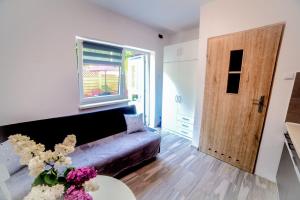 salon z kanapą, stołem i drzwiami w obiekcie U MICHAŁA w Świnoujściu
