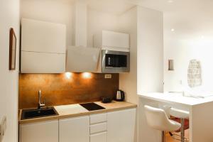 a kitchen with white cabinets and a sink and a microwave at Old Square Studio Apartment in Split