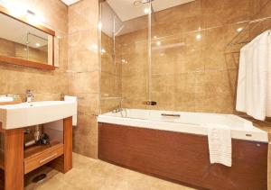 a bathroom with a bath tub and a sink at Cascade Wellness Resort in Lagos