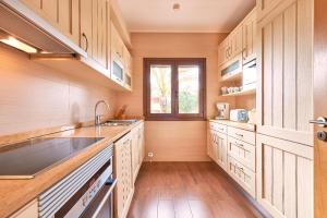 a kitchen with wooden cabinets and a sink and a window at Cascade Wellness Resort in Lagos