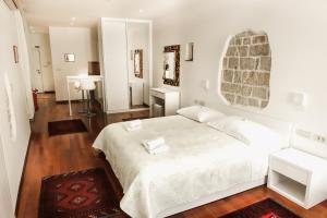 a white bedroom with a large bed with two towels on it at Old Square Studio Apartment in Split