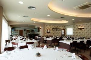un salón de banquetes con mesas y sillas blancas en La Noguera Camping, en Sant Llorenç de Montgai