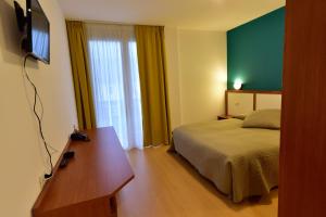 Habitación de hotel con cama y TV en Hotel La Pieve, en Pieve Vergonte