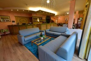 a living room with two blue couches and a kitchen at Hotel La Pieve in Pieve Vergonte