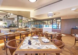 a restaurant with wooden tables and wooden chairs at Cascade Wellness Resort in Lagos