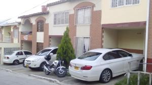 three cars parked in a parking lot in front of a building at Casa Alar Del Conde in San Gil